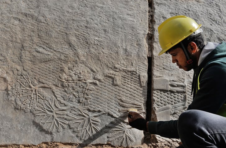 archaeologists with Assyrian reliefs