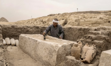 An Egyptian antiquities worker scrubs an embalming bed at the ancient workshop in Saqqara.